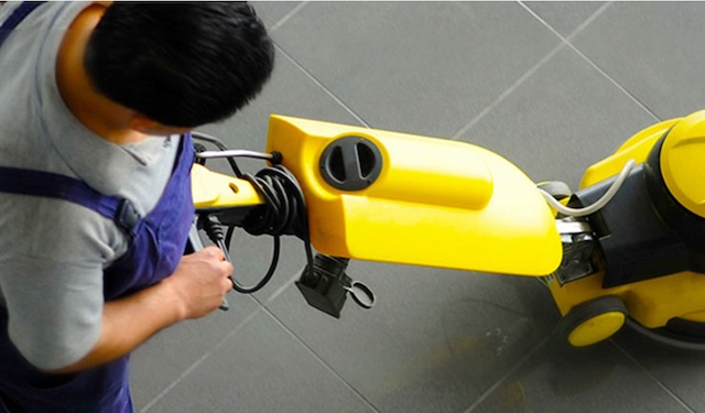 Technician vacuuming the floor using the MobiWork cleaning & sanitation services software solution