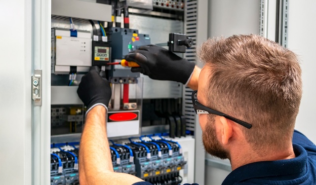 Technician working on electrical wiring using the MobiWork Electrical services software solution