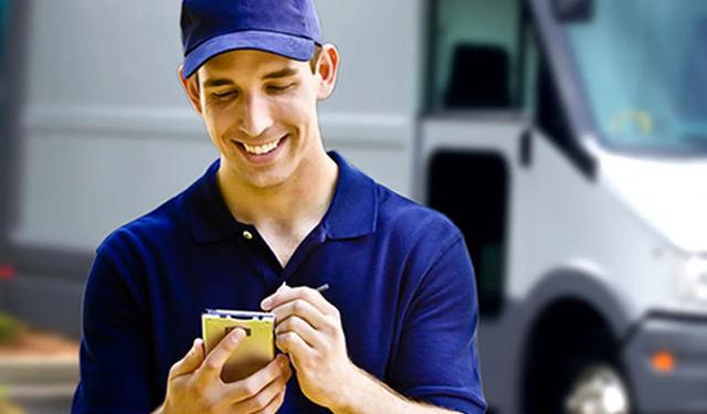 Delivery man standing in front of delivery truck using the MobiWork last mile delivery services software solution