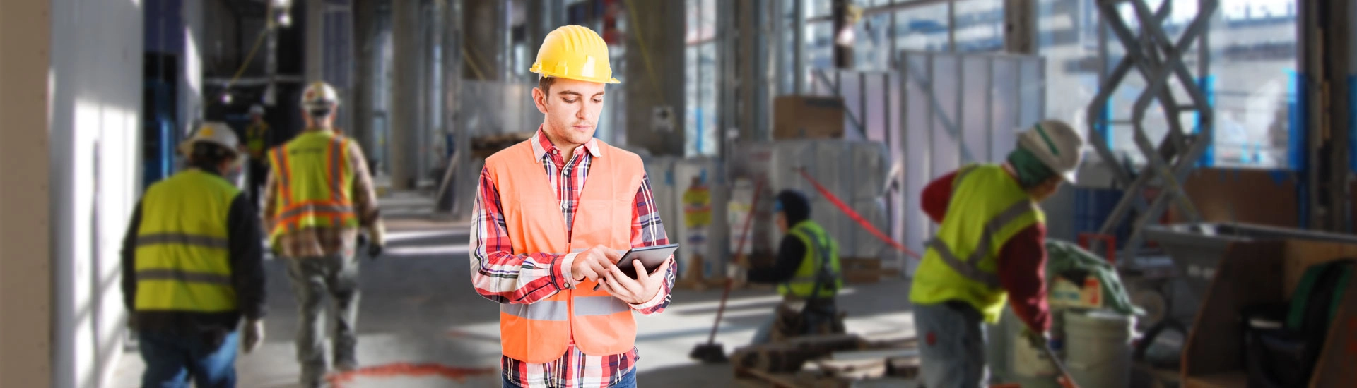 construction worker using a construction management software on his tablet